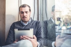 multitasking man using tablet, laptop and cellhpone