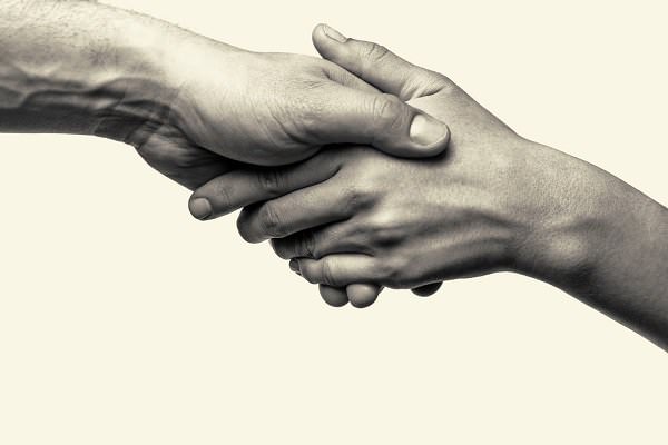 Both giving help and asking for it are our greatest expressions of the First Tradition. (SvetaZi/Shutterstock)