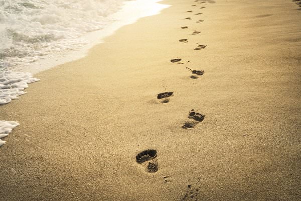 The “footprints in the sand” story isn’t a perfect analogy for how Tradition Two works, but it has some similarities. (Hitdelight/Shutterstock)