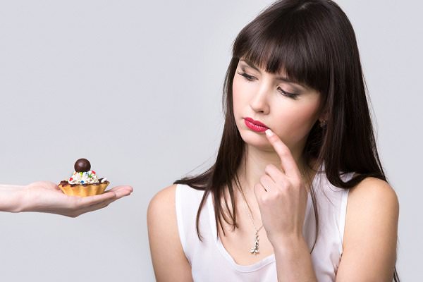 Temperance is a bit like the dilemma faced by the woman above. Just replace the tiny dessert with an excess of poisonous substances and massively self-destructive tendencies. (fizkes/Shutterstock)